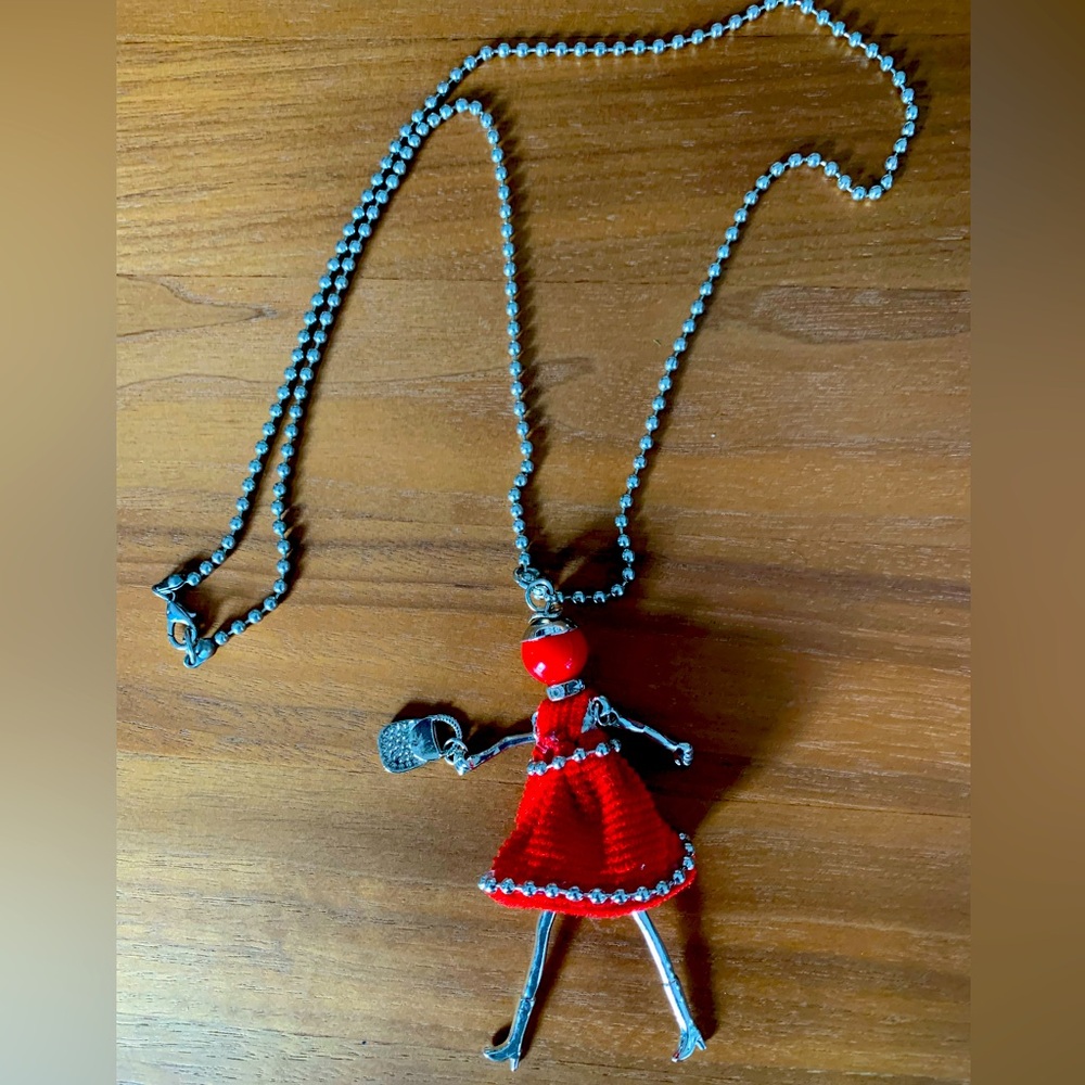 Fun ‘red dressed shopper’ necklace with crystals on neck. Arms & legs swing.
